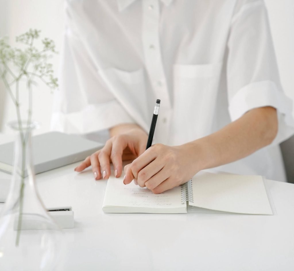 writing in a notebook to mark a personal milestone, reflecting a thoughtful moment of pause and meaningful choice
