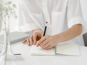 writing in a notebook to mark a personal milestone, reflecting a thoughtful moment of pause and meaningful choice